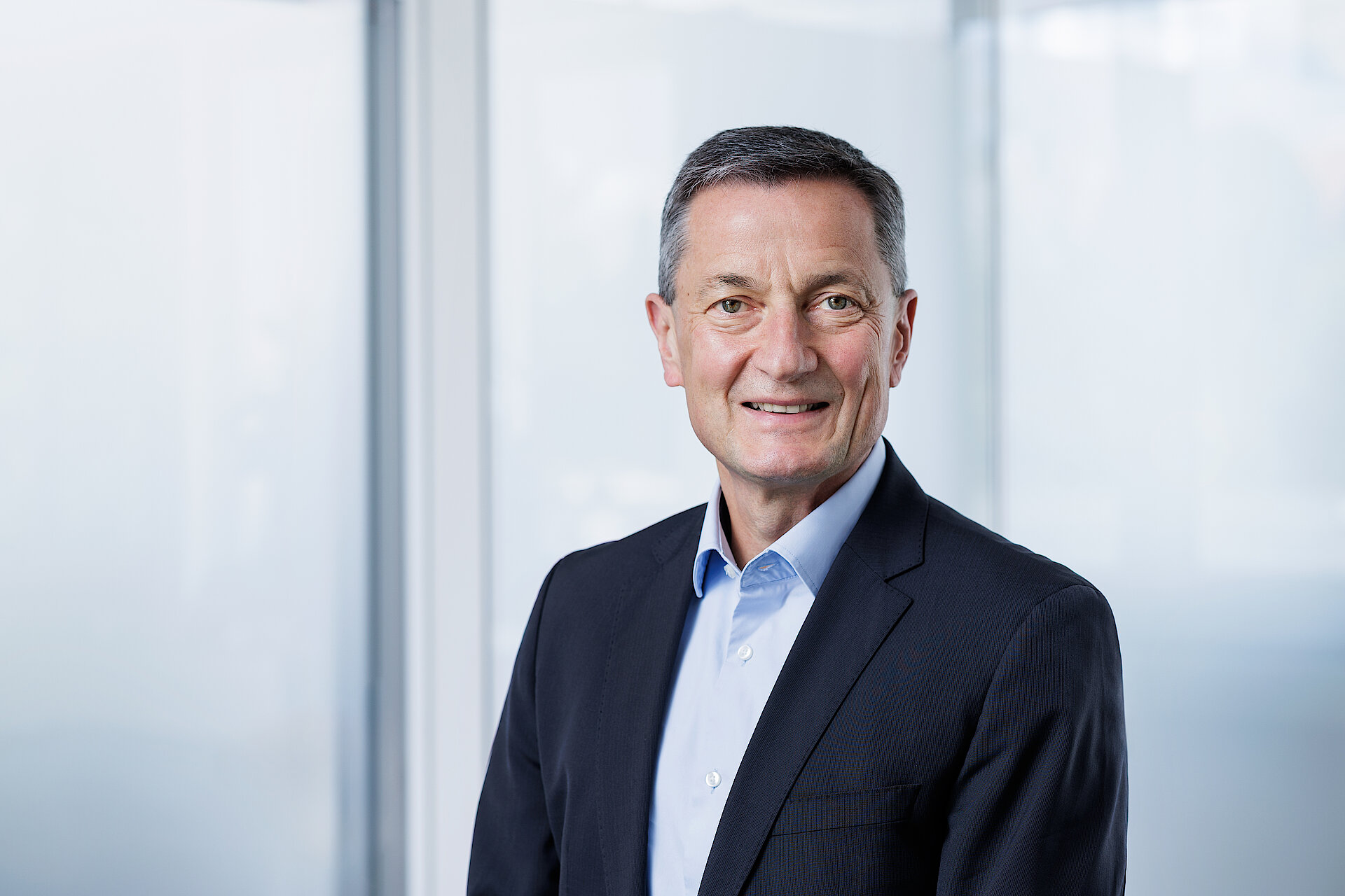 Hans-Werner Kaas in a suit against a light background.