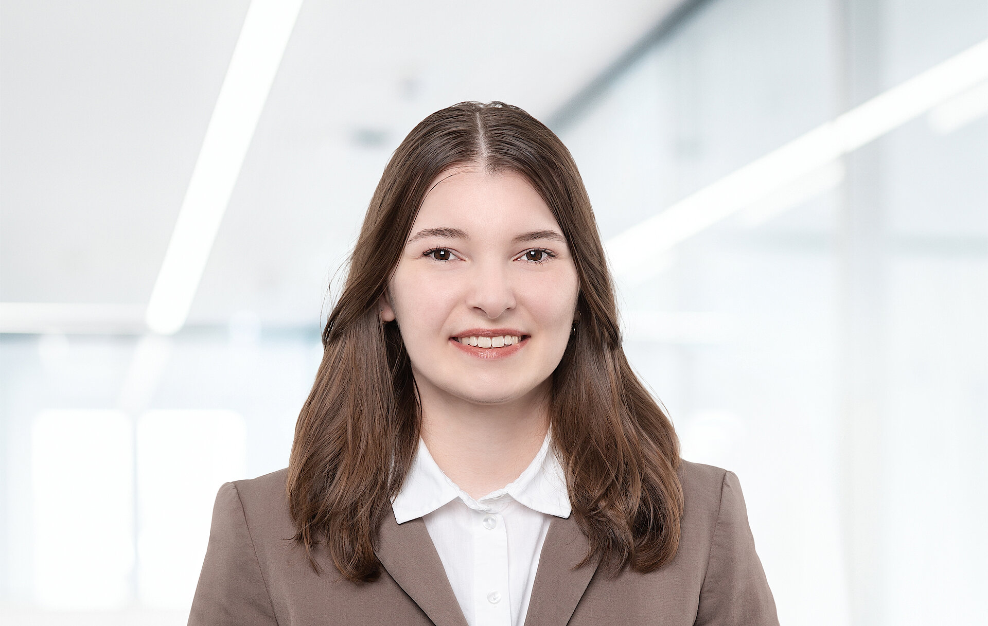 Portrait of a woman in a business suit smiling in an office setting.