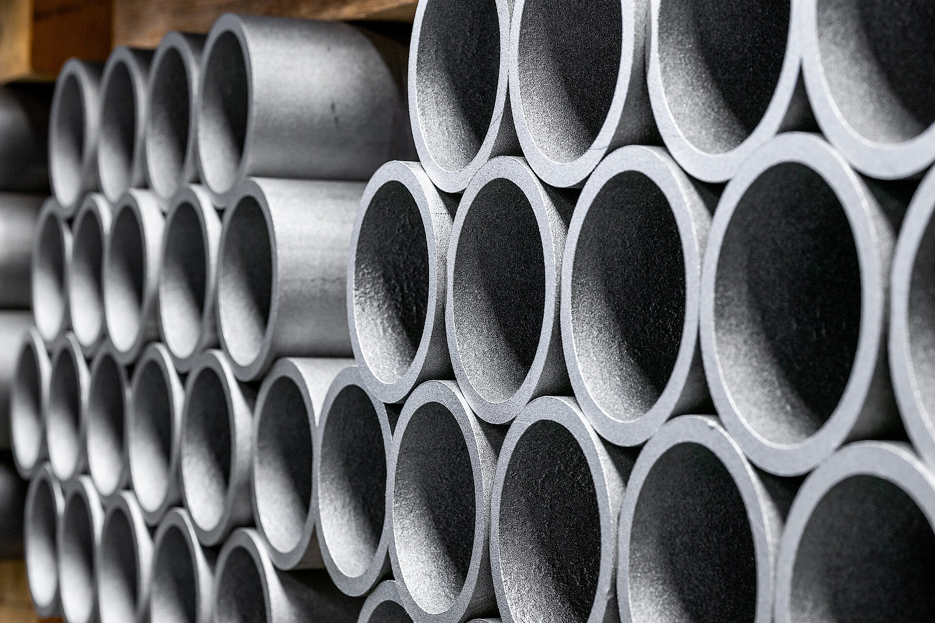 Axle tubes stacked in storage.